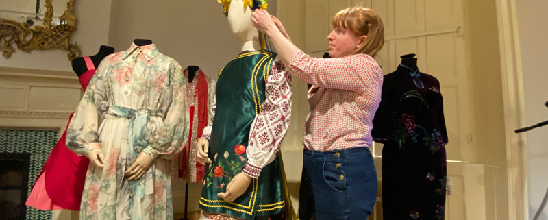 Curator of dress and textiles making adjustments to Ukrainian dress on display at Lotherton