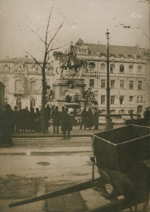 A sepia photograph of a statue and people standing around it