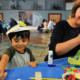 Child and parent crafting at Leeds City Museum with paper plates