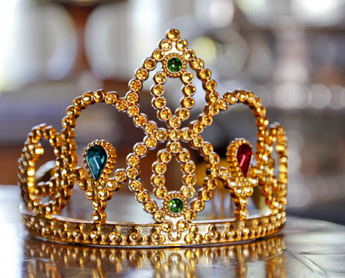 A children's crown sat on a wooden table