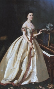 A painting of a woman standing next to a piano. She's wearing a cream silk ballgown with red trimming details and a gold necklace.