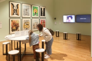 A woman and a child are pointing at something on the round table in the Shifting perspectives exhibition