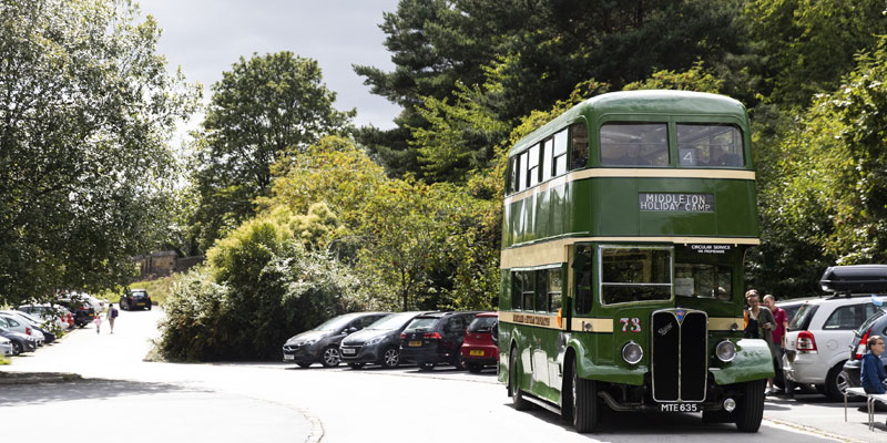 A green vintage bus is parked up in the carpark of Leeds Industrial Museum