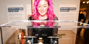 A person looking at an object in a case in the Living with Machines exhibition at Leeds City Museum