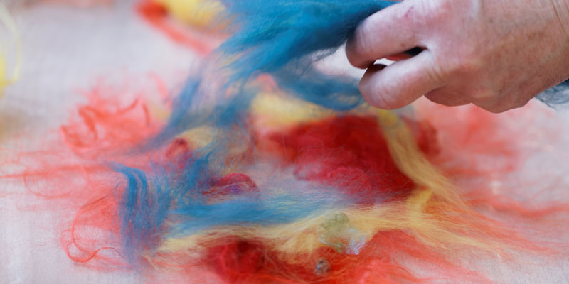 wet felting using shades of blue, yellow and red