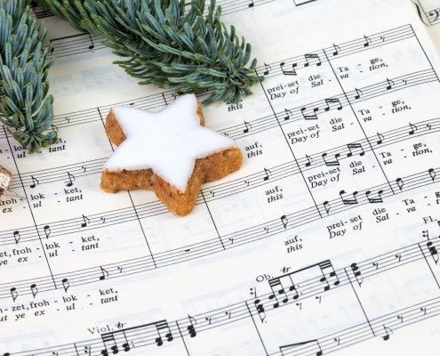 Christmas decorations lying on a page of sheet music for a choir
