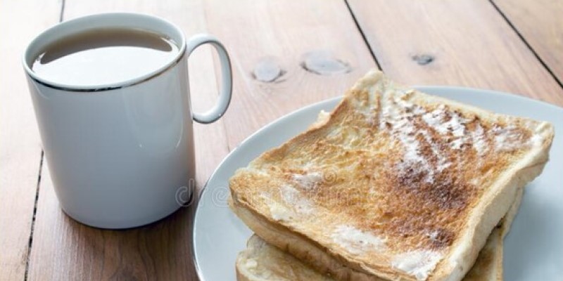A cup of tea and a plate of buttered toast