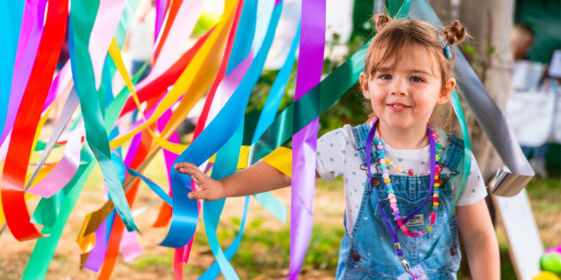 Young child with colourful ribbons outdoors