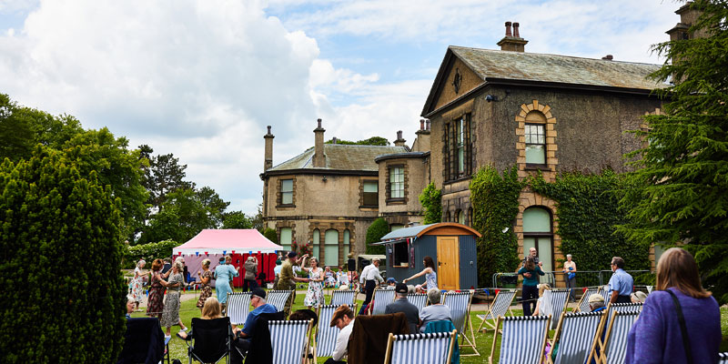 Lotherton hall with people and deck chairs in the garden