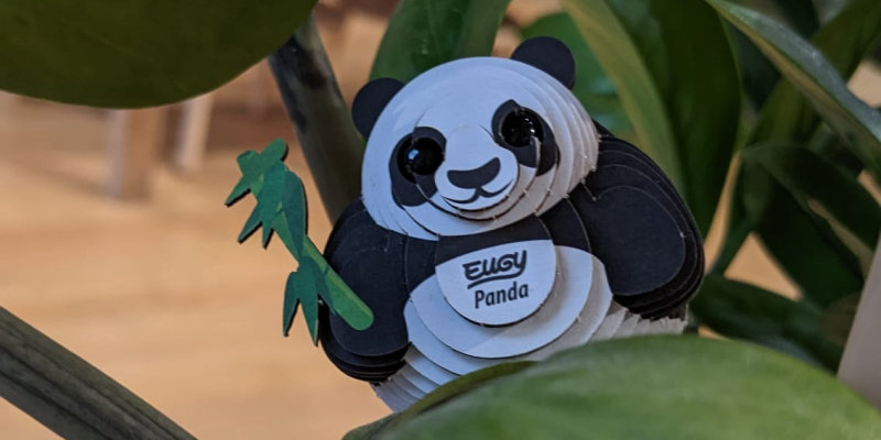 A small panda made from card hiding in a plant at Leeds City Museum