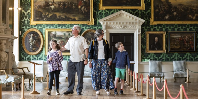 Two adult and two children in the Picture Gallery at Temple Newsam looking at paintings on the walls