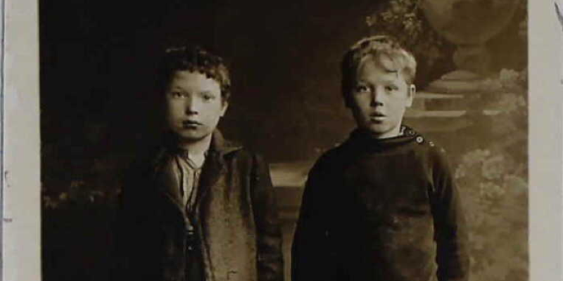 Black and white photograph of two children in Victorian clothing