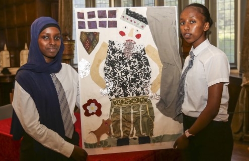 two schoolchildren with a portrait that they have created