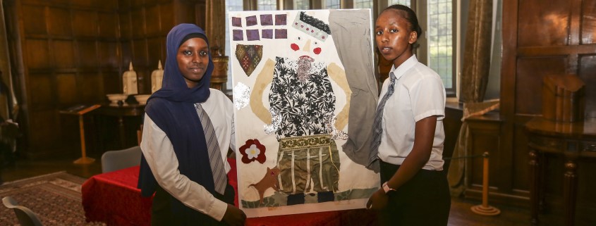 two schoolchildren with a portrait that they have created