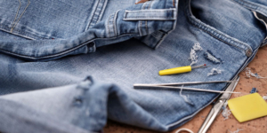 Jeans being patched up with sewing items