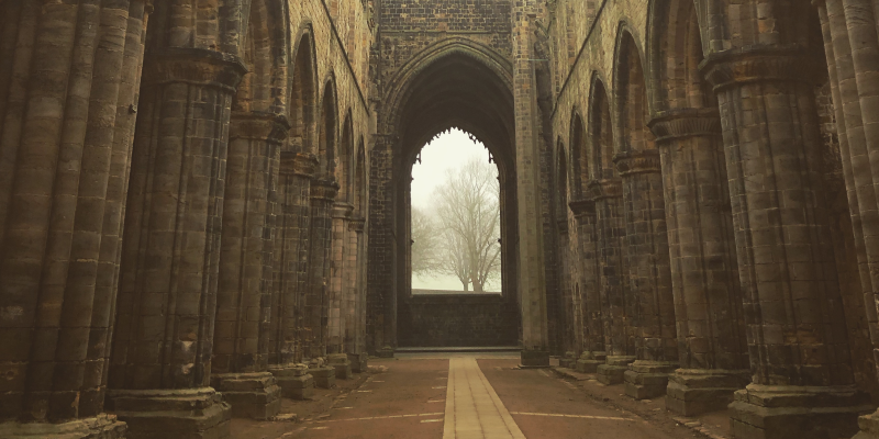 the nave of kirkstall abbey with mist