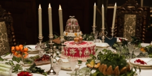 a table set with candles, flowers, fruit, and cakes