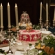 a table set with candles, flowers, fruit, and cakes
