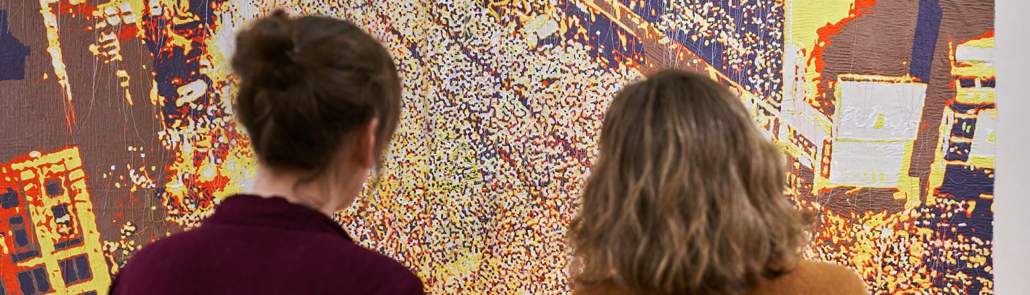 two people looking at a golden shiny artwork