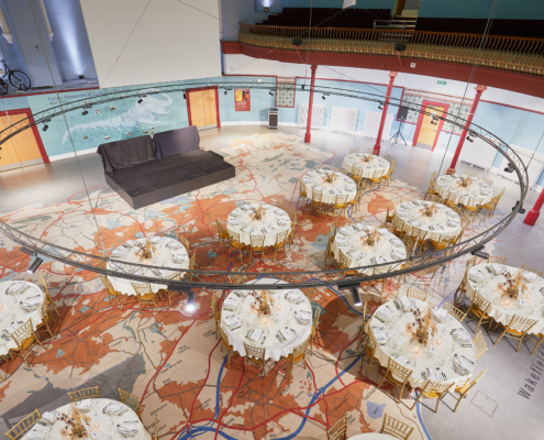 An aerial view of a circular room with 11 round tables in