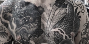 large tattoos of a bear and a pelican on a person's back