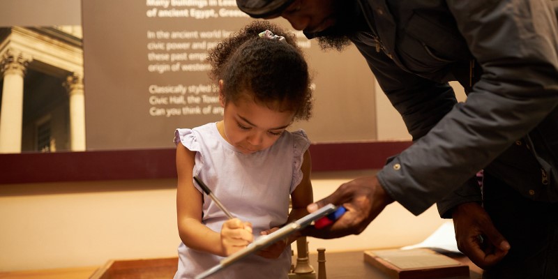 a child writing on a clipboard