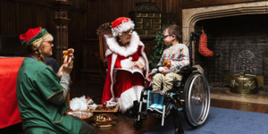 Mrs Claus reading a festive story to a child and Mrs Claus' elf at Temple Newsam.