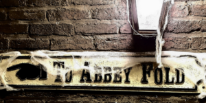 Victorian style street sign saying Abbey Fold with cobwebs on it