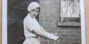 black and white photograph of a young girl wearing a bicycle